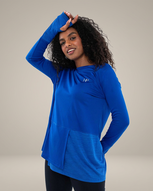 Royal Blue – Yasmeen colour-block panel sports top, arm raised, showing the panel detail