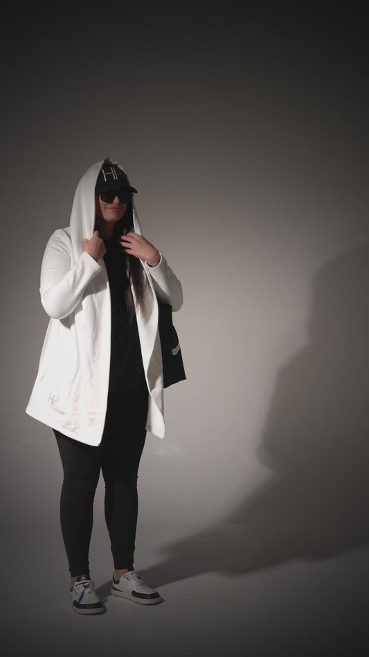White hooded long jacket and black Humble Power bag, with a friend in a beige co-ord