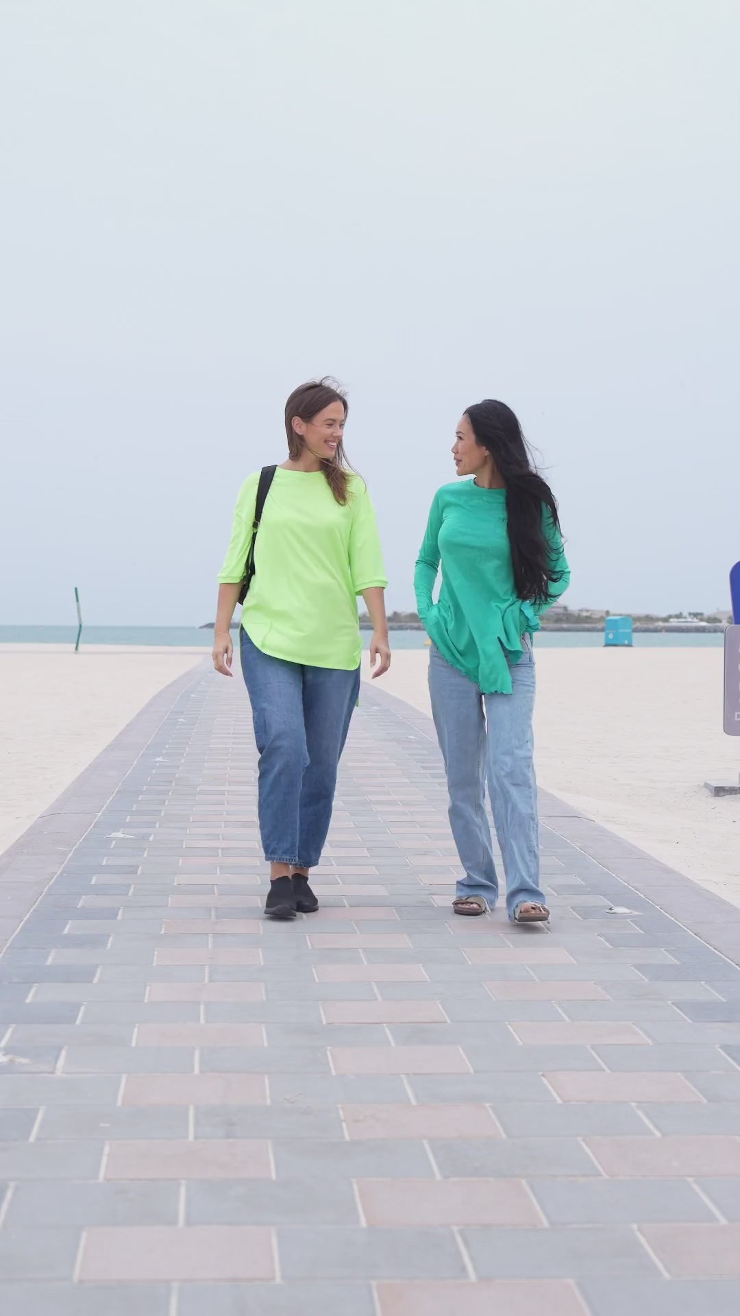 Friends on a beach day out in long modest tops and jeans