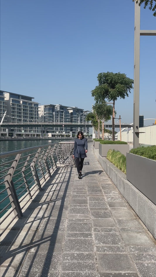 Ayana double-skirt long top in purple, walking by the water in Dubai