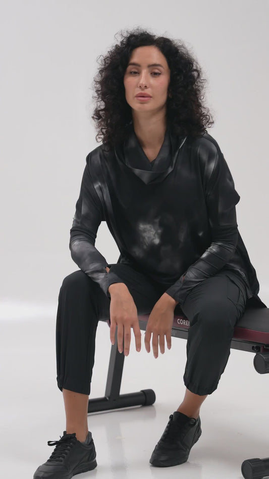 Woman doing dumbbell rows on a bench in a black modest top