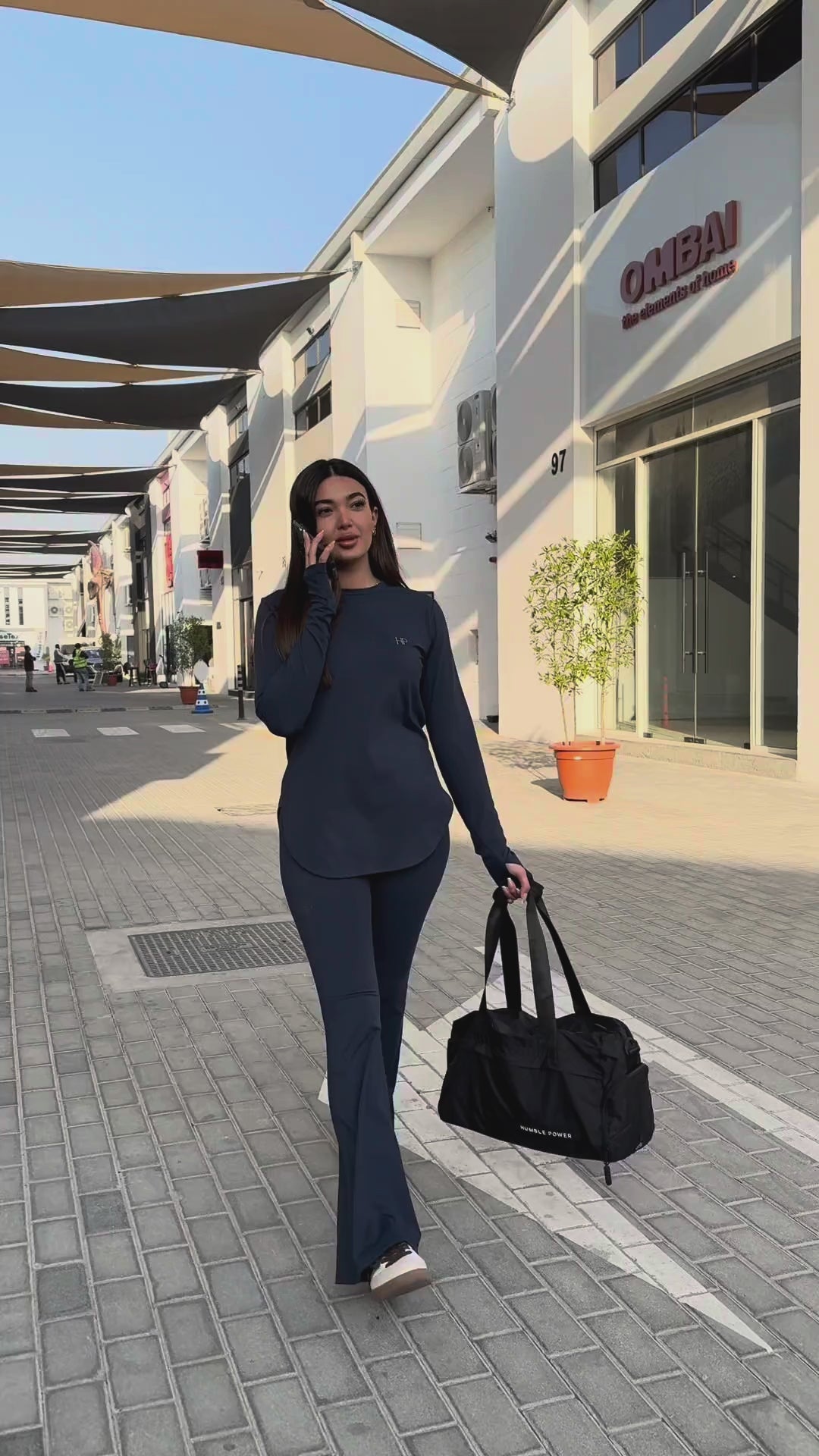 Navy long top with curved hem and navy flare leggings, carrying the Humble Power bag