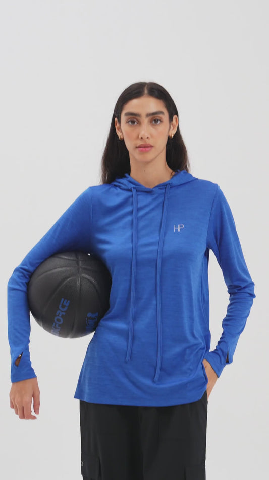 Woman spinning a basketball in a blue modest sports hoodie