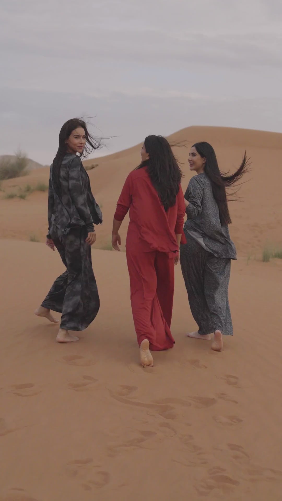Three women in the desert at sunset wearing Siena shirt and pants sets in red, charcoal tie-dye and grey