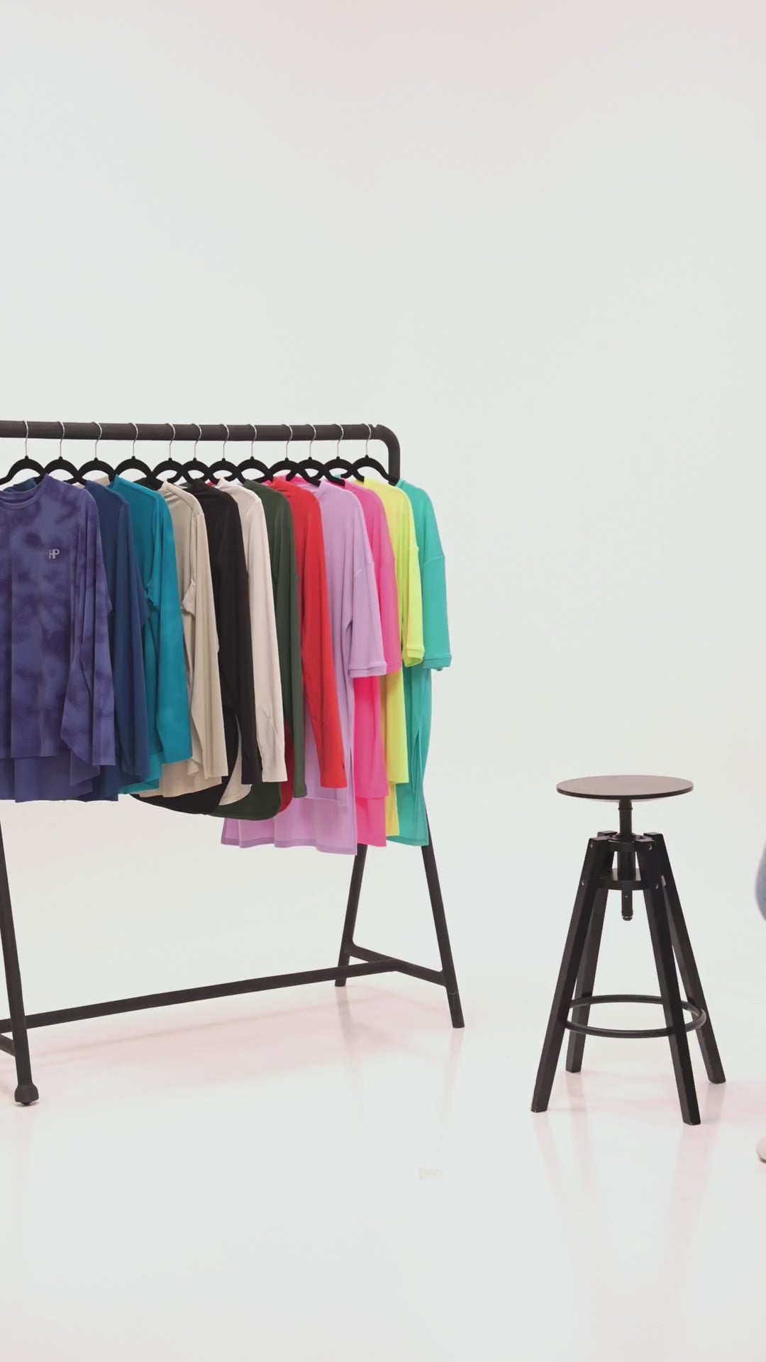 Try-on with wide jeans: dark printed, blue and teal long tops and a beige jacket, with the Humble Power backpack