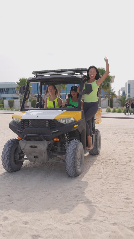 Friends at the beach by a lifeguard buggy in modest activewear