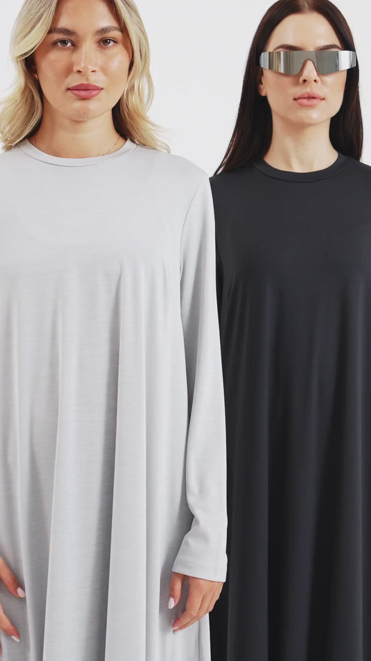 Two women walking in long black and white walking abayas