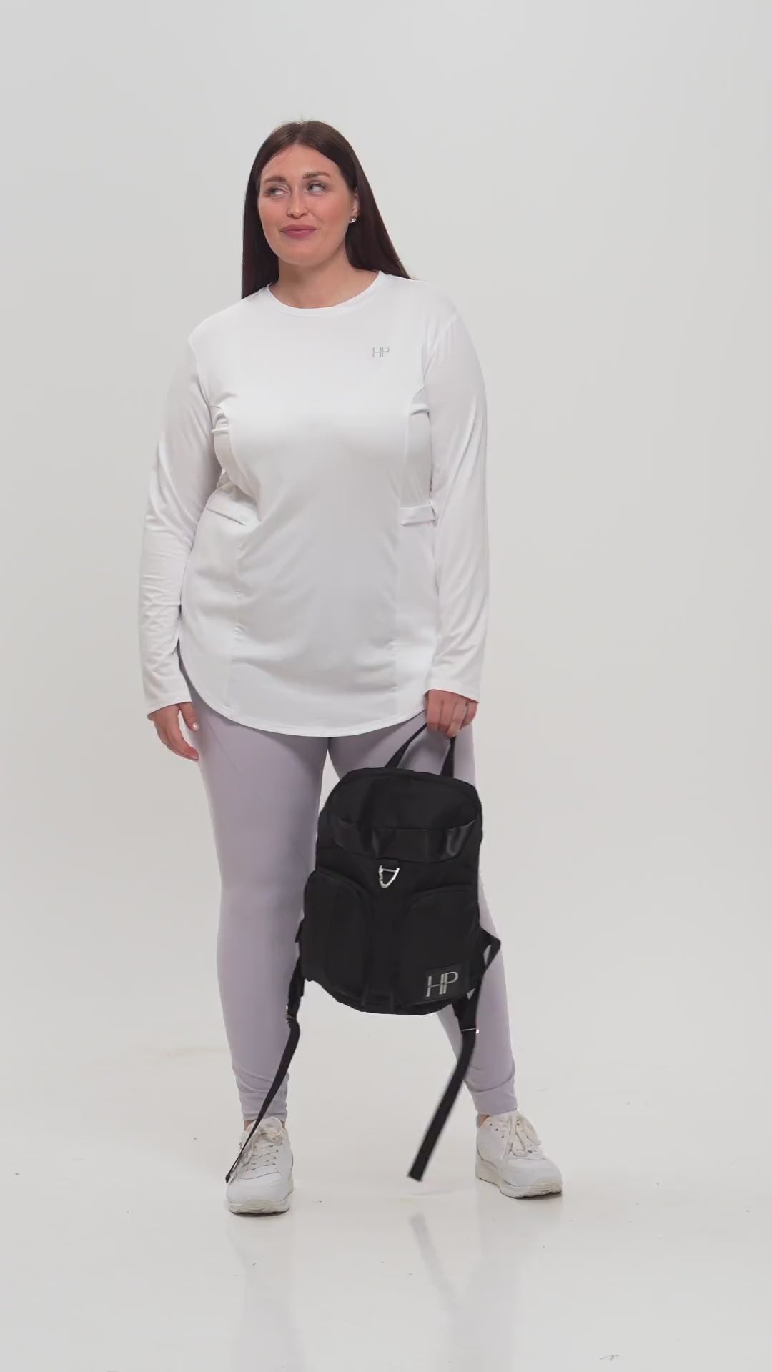 Plus-size model in a black zip jacket and leggings, carrying a Humble Power bag