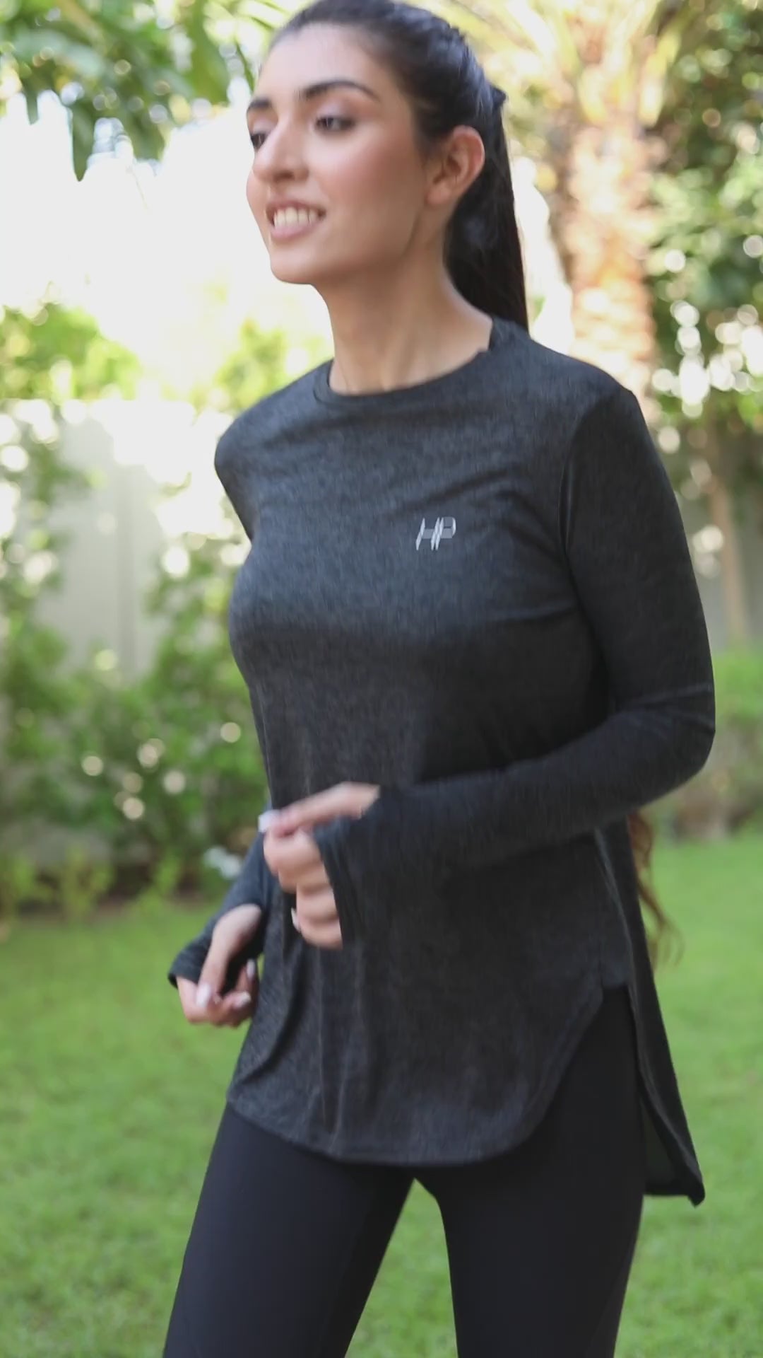 Two women training in a garden with resistance bands and lunges, including a khaki top with a cream V-panel on the back