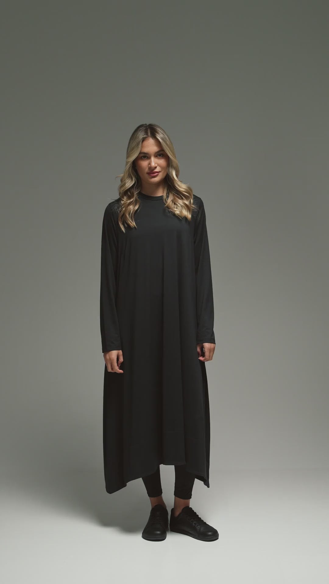 Woman in a long black walking abaya receiving flowers