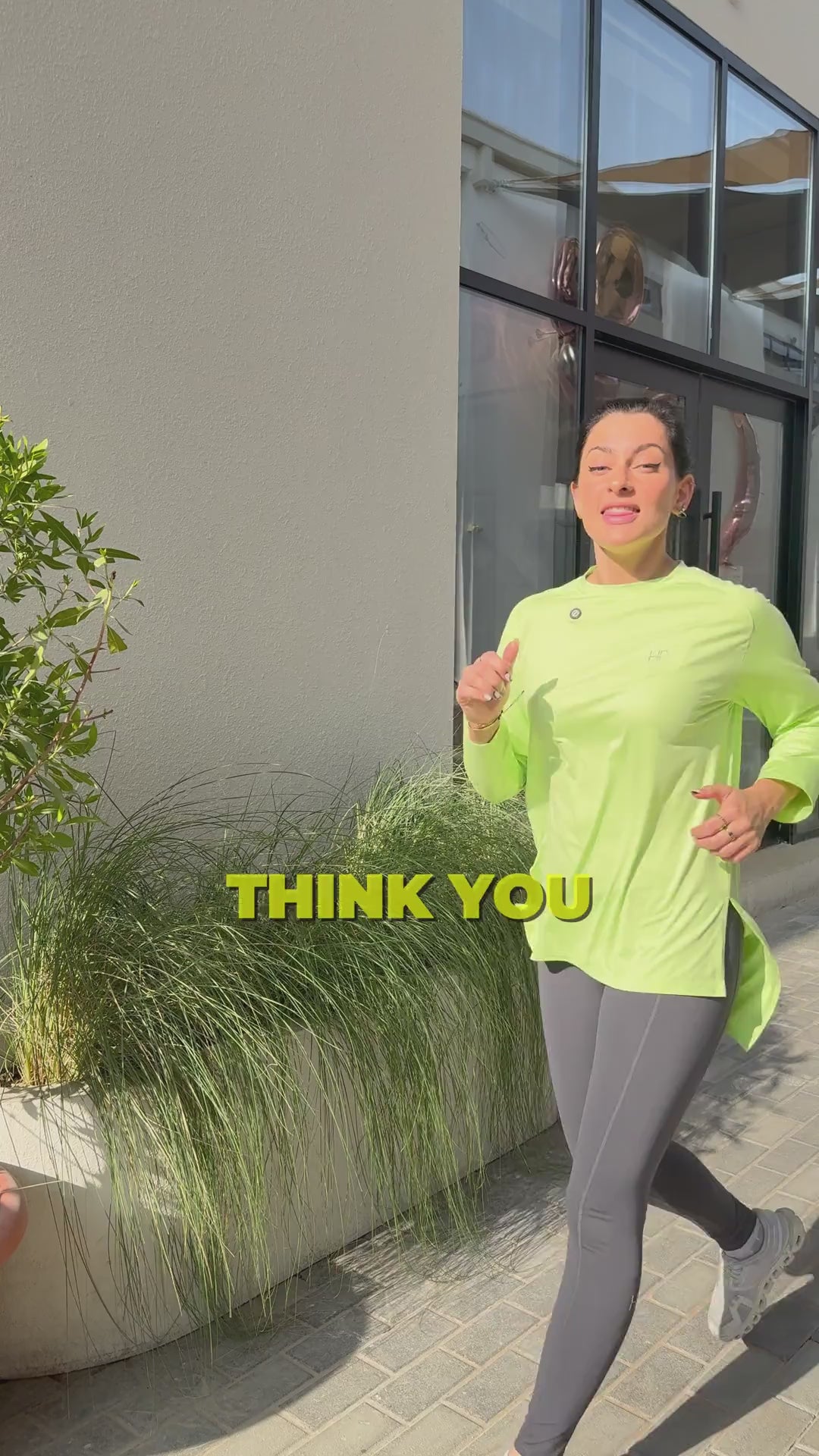 Neon-yellow long modest top and grey leggings, talking about activewear myths